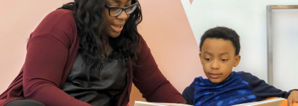 a woman and a boy reading a children's storybook together.