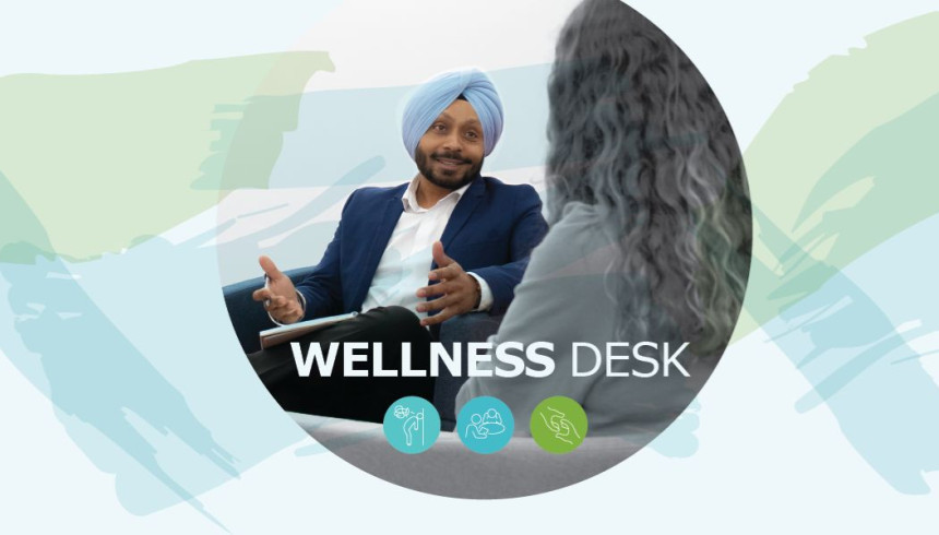 A photograph of a man sitting with a pen and notebook and talking to a woman. Wellness Desk is written over the image, and underneath is a visual of three different dots with icons inside them.