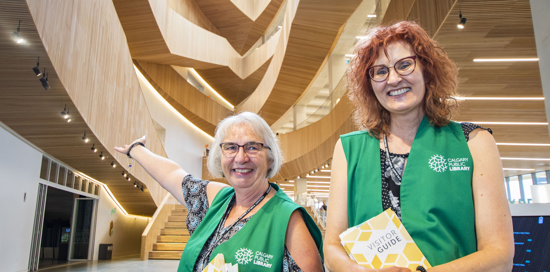 Two Calgary Library Volunteers are welcoming patrons to the Central library.