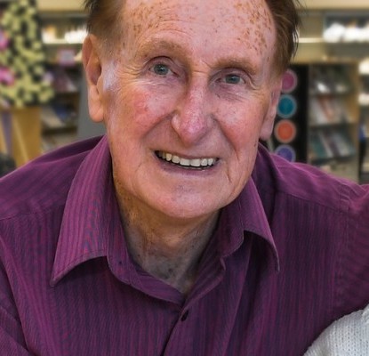 Frank OKeeffe and an elderly woman sitting at a table in a library.