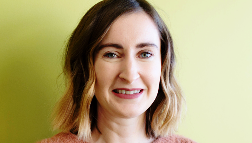 Rachel Murphy standing in front of a green wall.