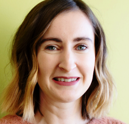 Rachel Murphy standing in front of a green wall.