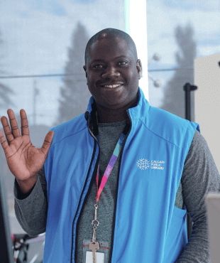 Staff member smiling at the camera and waving. 